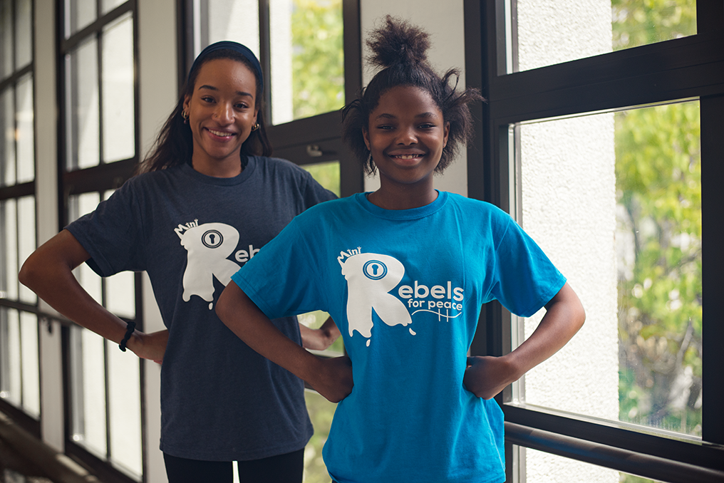 Woman in hijab sitting at table, smiling and part of group of discussion