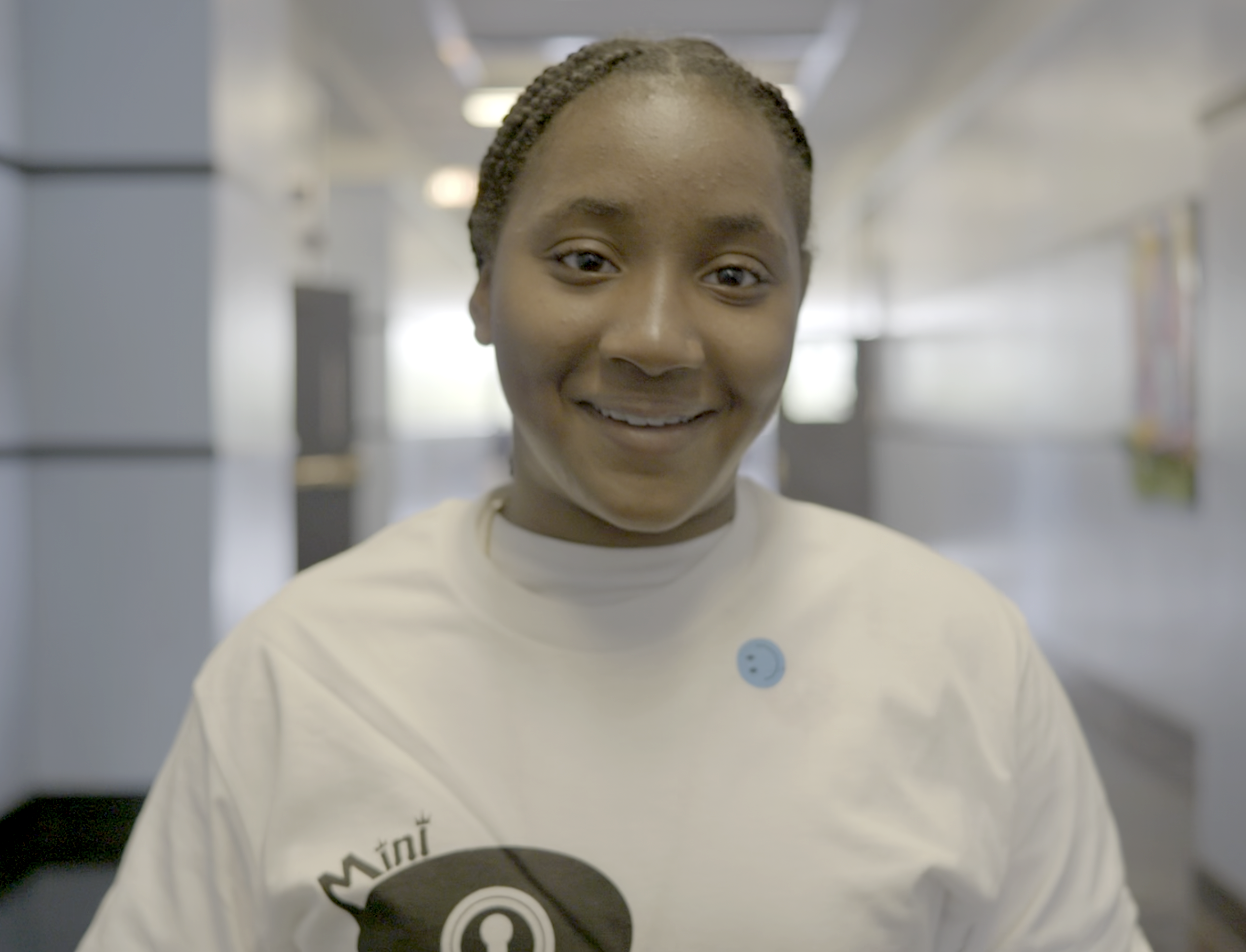Woman in hijab sitting at table, smiling and part of group of discussion