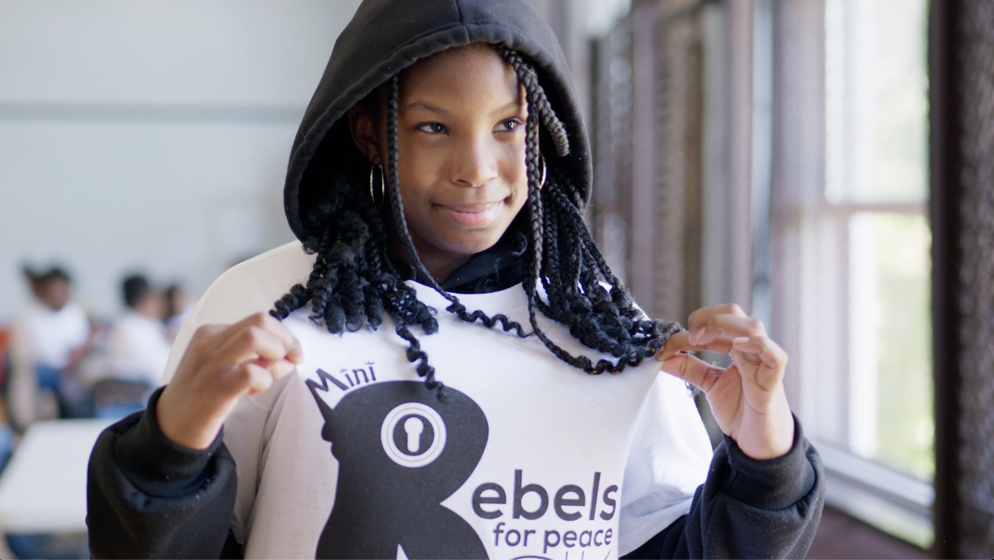 Woman in hijab sitting at table, smiling and part of group of discussion