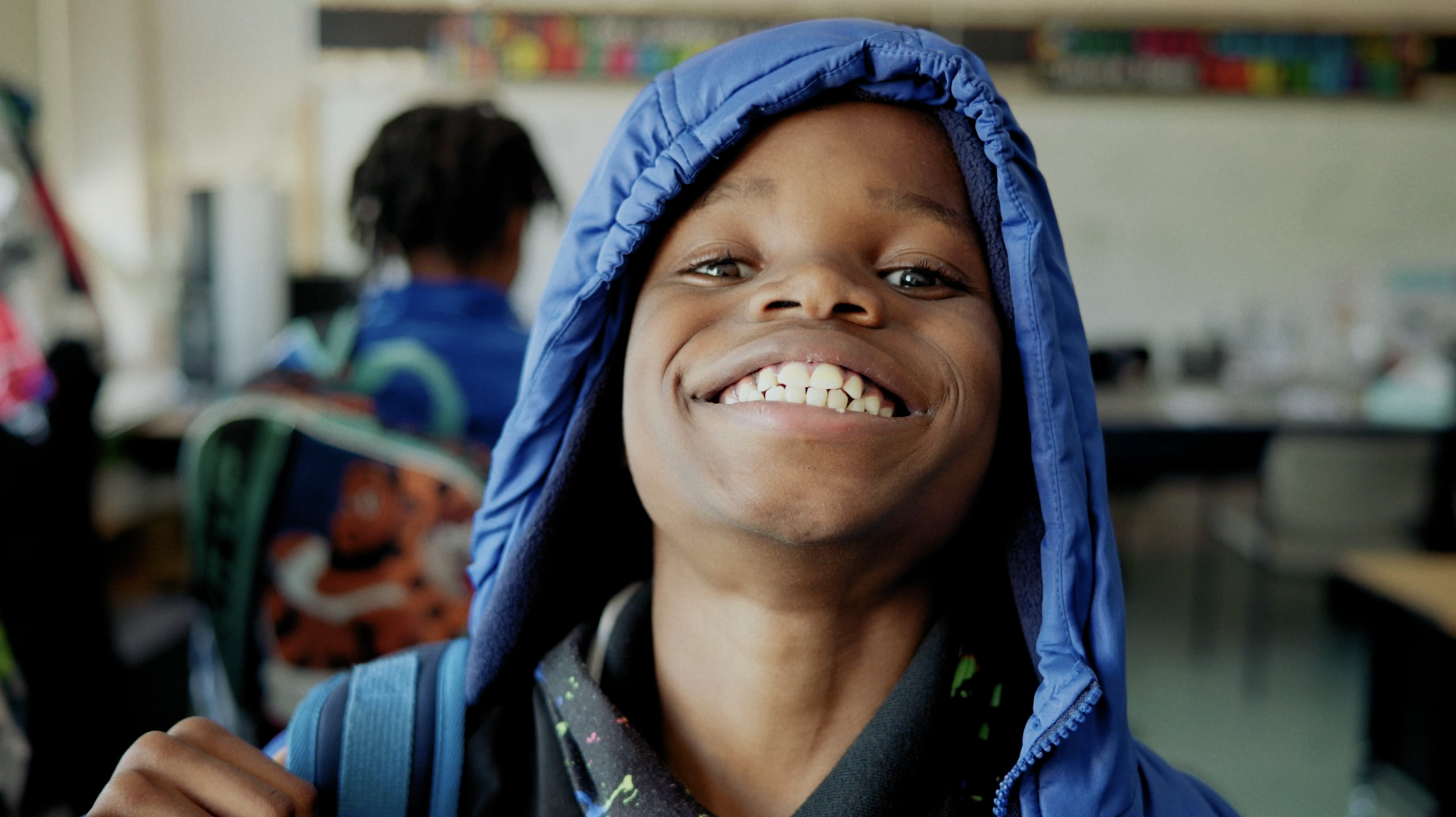 Woman in hijab sitting at table, smiling and part of group of discussion